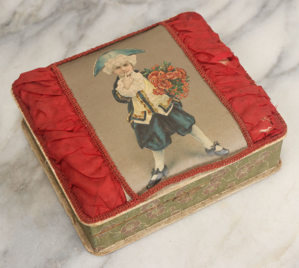 Lot 085 - Antique Paper Board Candy Box With Tufted Red Fabric, Blue Boy With Flowers Graphic On Cover