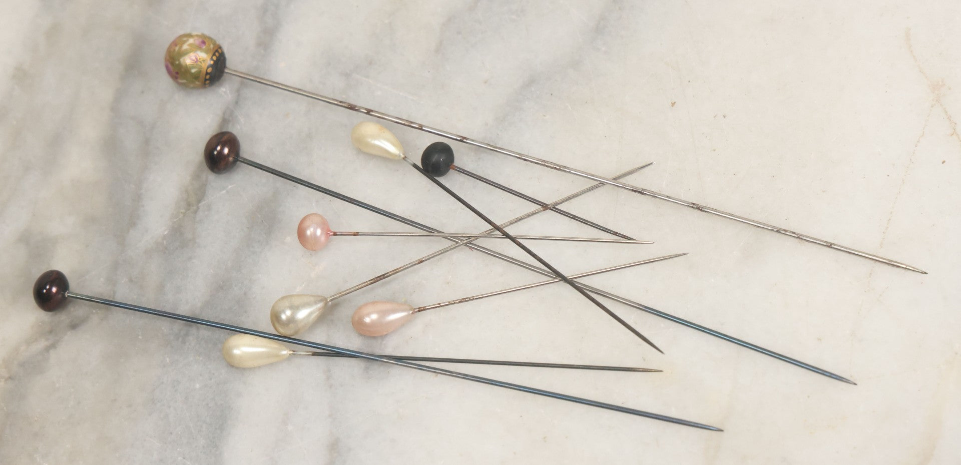 Lot 088 - Grouping Of Nine Vintage Hat Pins Including Pin With Painted Head With Purple Flowers, Mother Of Pearl Pin Heads, And More