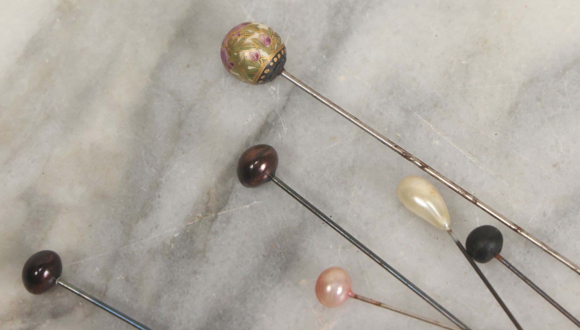Lot 088 - Grouping Of Nine Vintage Hat Pins Including Pin With Painted Head With Purple Flowers, Mother Of Pearl Pin Heads, And More