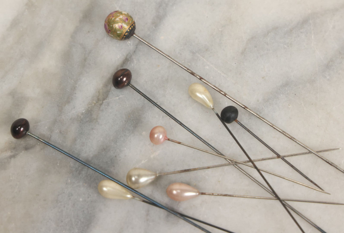 Lot 088 - Grouping Of Nine Vintage Hat Pins Including Pin With Painted Head With Purple Flowers, Mother Of Pearl Pin Heads, And More