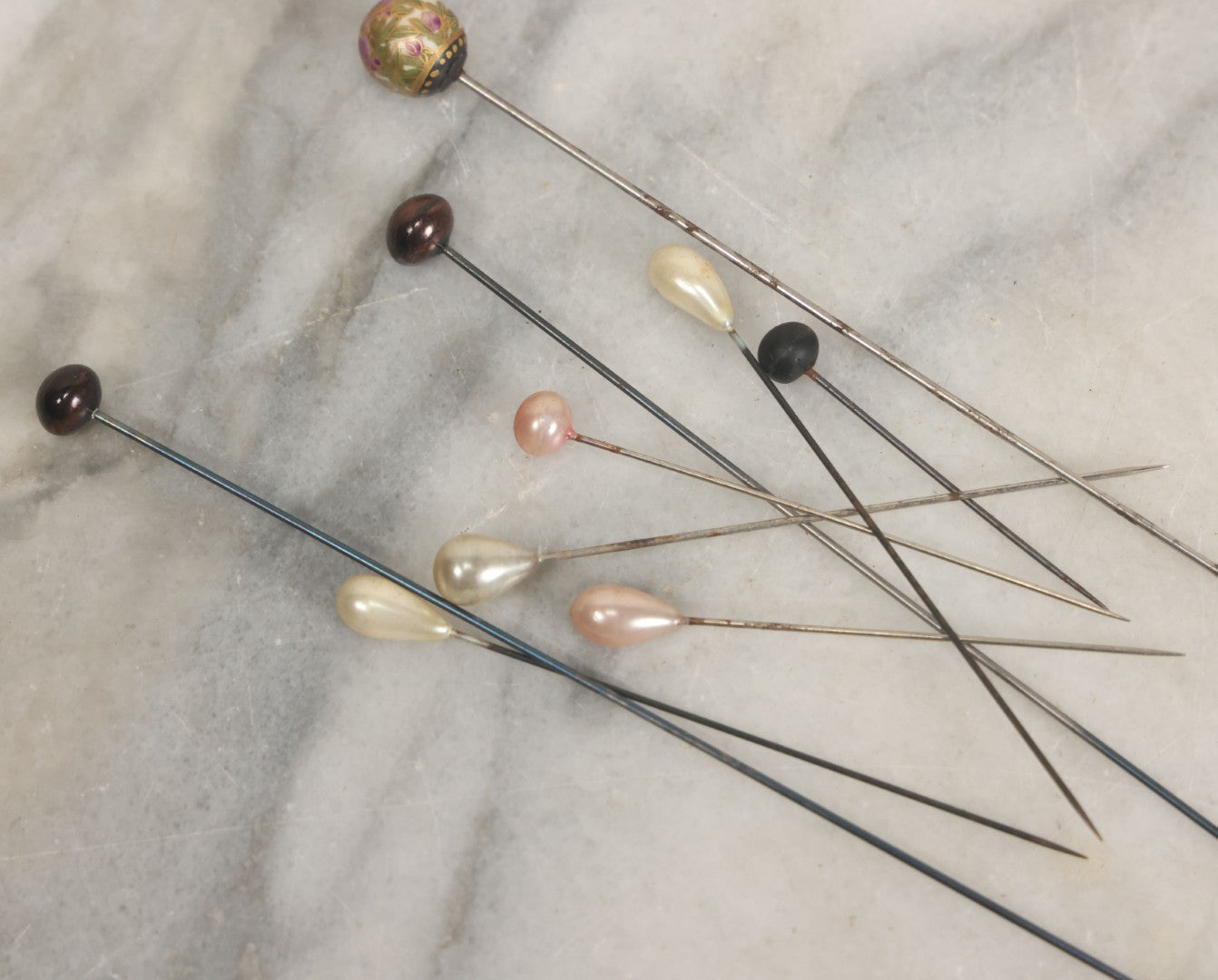 Lot 088 - Grouping Of Nine Vintage Hat Pins Including Pin With Painted Head With Purple Flowers, Mother Of Pearl Pin Heads, And More