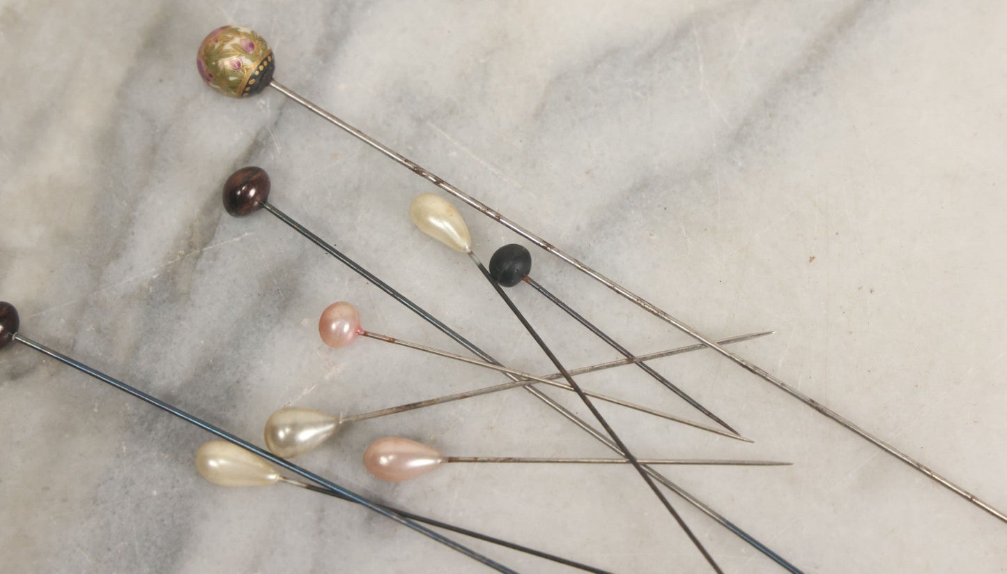 Lot 088 - Grouping Of Nine Vintage Hat Pins Including Pin With Painted Head With Purple Flowers, Mother Of Pearl Pin Heads, And More