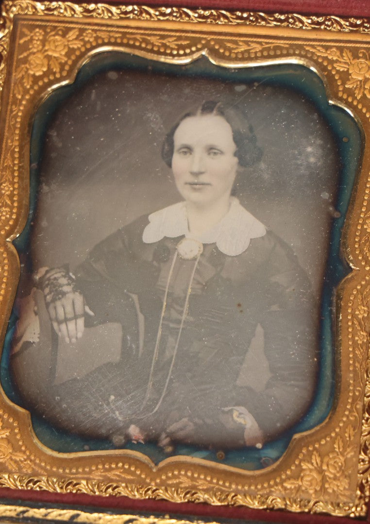 Lot 115 - Antique 1/6th Plate Daguerreotype Photograph Of Young Woman Wearing Black Lace Gloves And Large Brooch In Leatherette Folder Case With Latch, "Bijou" Lettering On Spine, Identified As Anna Matilda Blackledge, Note Partial Tear On Case Cover
