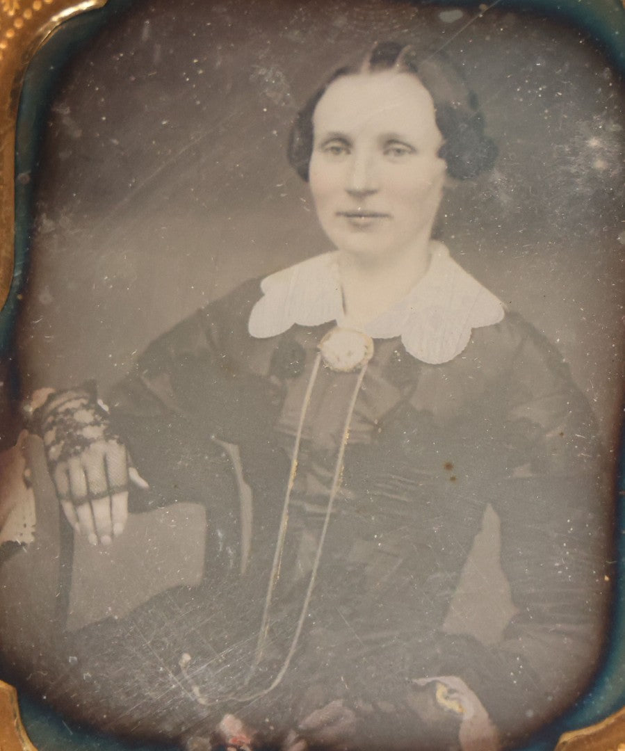 Lot 115 - Antique 1/6th Plate Daguerreotype Photograph Of Young Woman Wearing Black Lace Gloves And Large Brooch In Leatherette Folder Case With Latch, "Bijou" Lettering On Spine, Identified As Anna Matilda Blackledge, Note Partial Tear On Case Cover