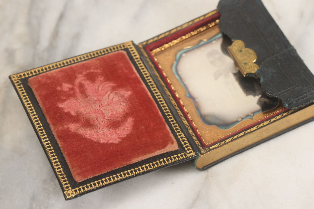 Lot 115 - Antique 1/6th Plate Daguerreotype Photograph Of Young Woman Wearing Black Lace Gloves And Large Brooch In Leatherette Folder Case With Latch, "Bijou" Lettering On Spine, Identified As Anna Matilda Blackledge, Note Partial Tear On Case Cover