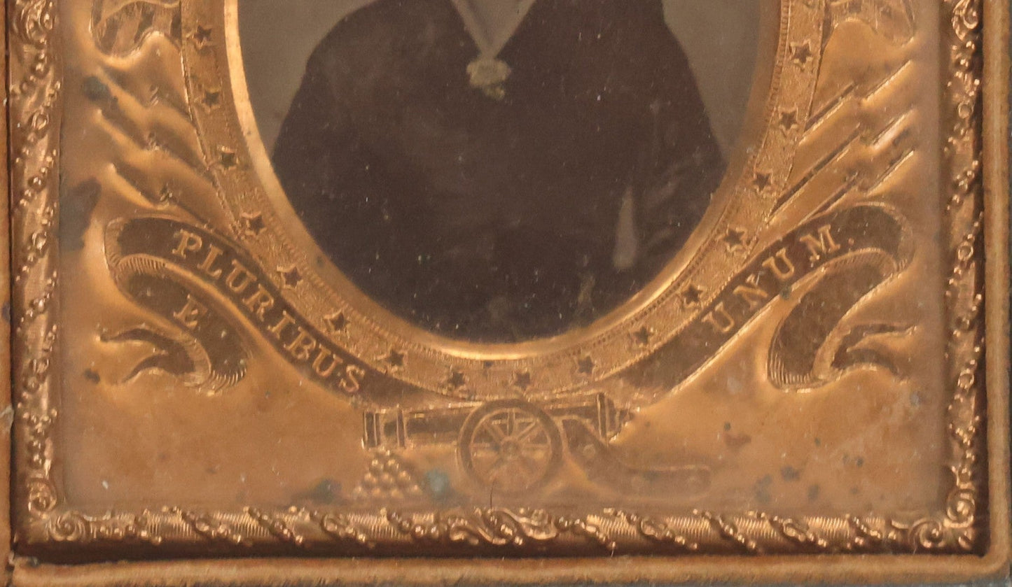 Lot 117 - Antique 1/6th Plate Ambrotype Photograph Of Solemn Woman In Dark Clothing With Patriotic Civil War Era Brass Mat With American Flags, Eagle, Cannon, "E Pluribus Unum" Banner, In Half Case