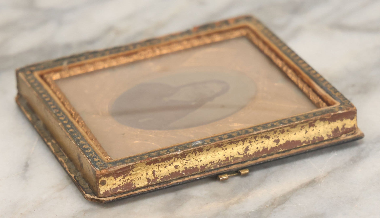Lot 117 - Antique 1/6th Plate Ambrotype Photograph Of Solemn Woman In Dark Clothing With Patriotic Civil War Era Brass Mat With American Flags, Eagle, Cannon, "E Pluribus Unum" Banner, In Half Case