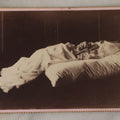 Lot 027 - Antique Cabinet Card Postmortem Photograph Of Baby Laying On Pillows With Dark Background, J.H. Langhans, Photographer, Little Valley, New York