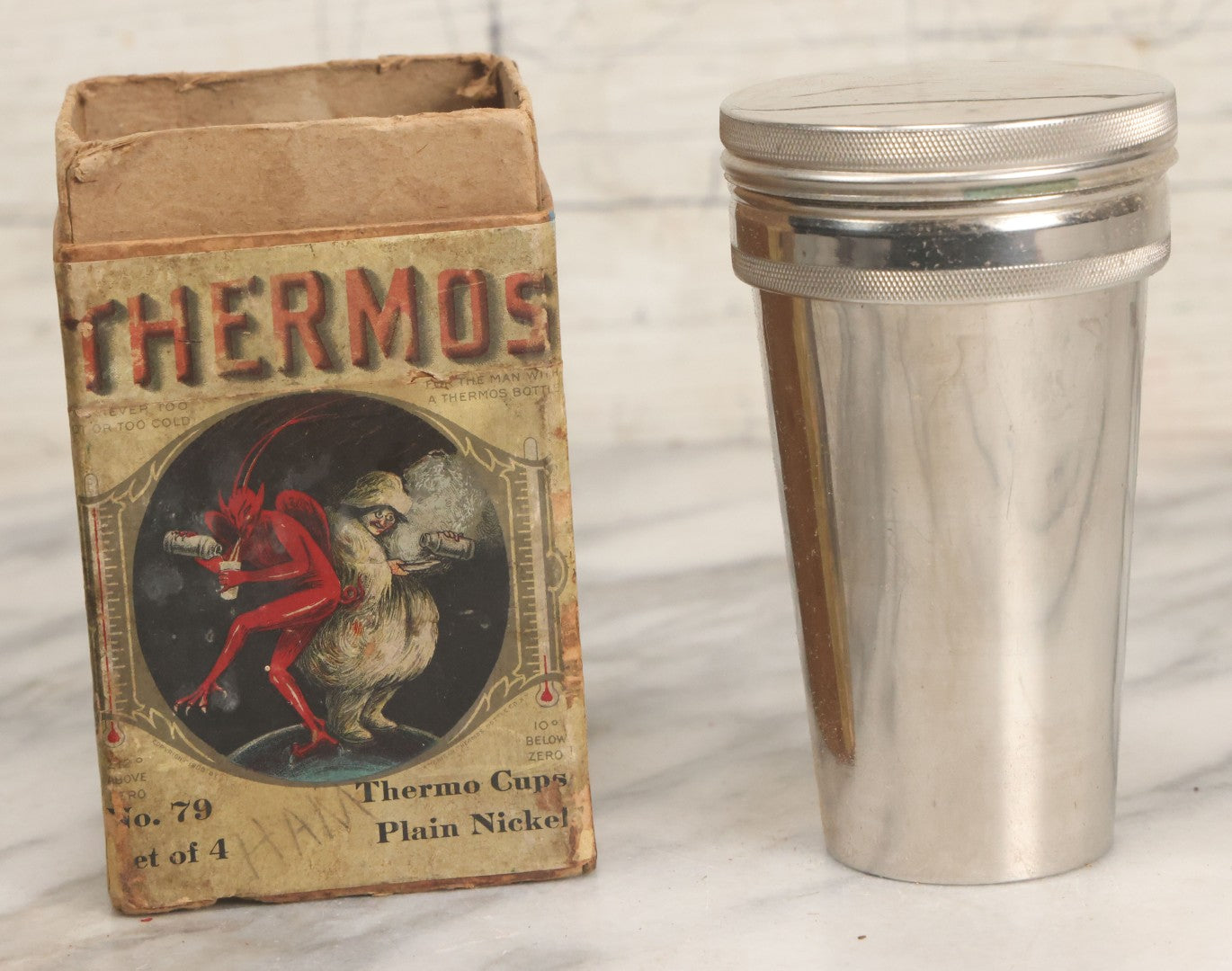 Lot 048 - Antique Thermos Brand Thermo Cup Set Of Four Plain Nickel Cups No. 79, With Original Box With Devil Graphics, Manufactured By The American Thermos Bottle Co., New York, Patented 1912, Complete Set