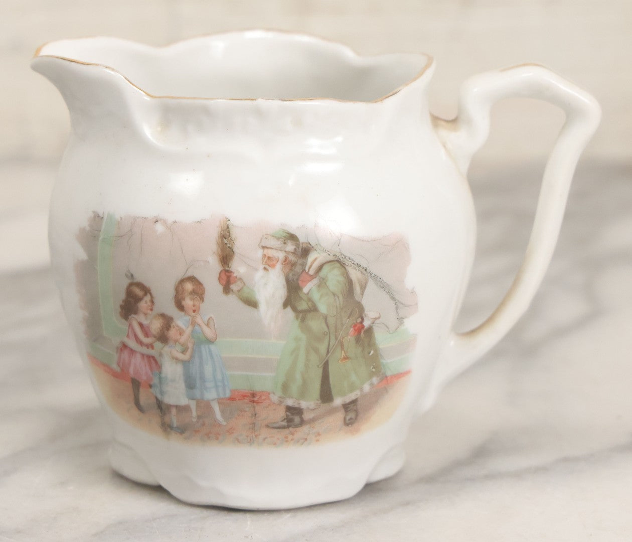 Lot 065 - Antique Porcelain Cream Pitcher With Christmas Theme, Santa Claus In Green Greeting Children With Presents, Likely Made In Germany, Unmarked