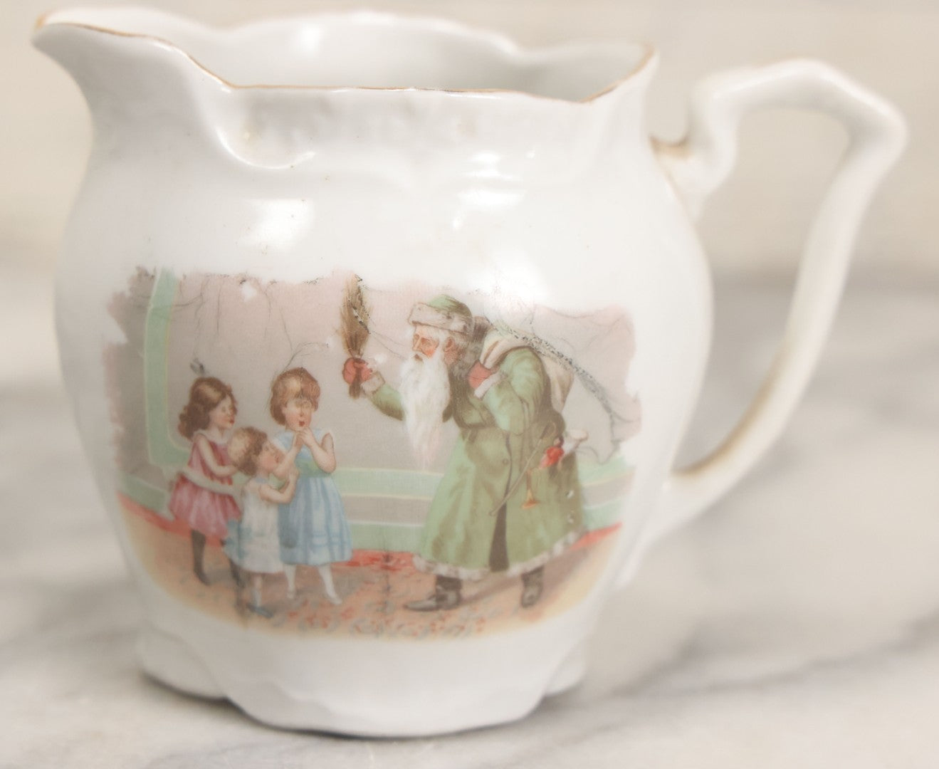 Lot 065 - Antique Porcelain Cream Pitcher With Christmas Theme, Santa Claus In Green Greeting Children With Presents, Likely Made In Germany, Unmarked