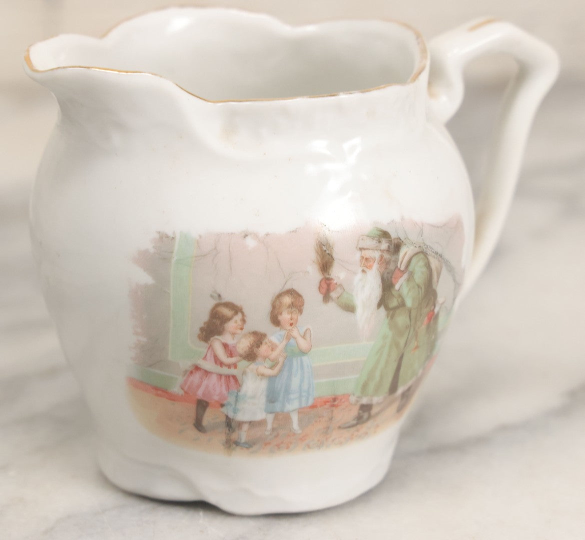 Lot 065 - Antique Porcelain Cream Pitcher With Christmas Theme, Santa Claus In Green Greeting Children With Presents, Likely Made In Germany, Unmarked