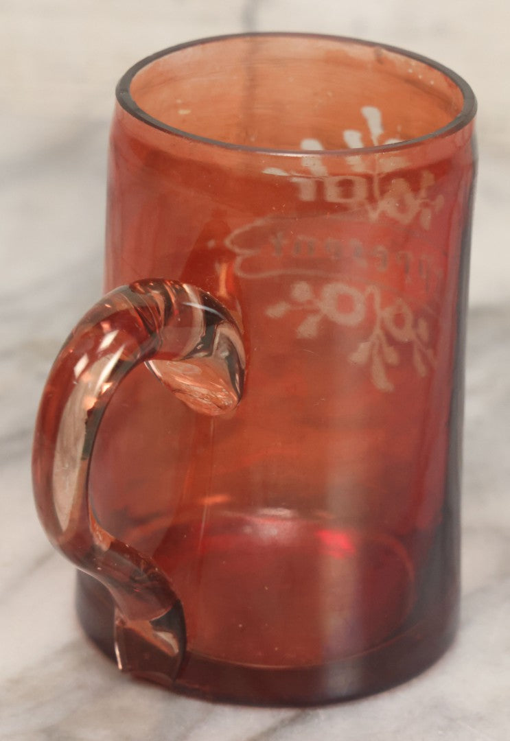 Lot 066 - Antique Ruby Glass Mug With Hand Etched, Hand Painted Details, "A Present" With Flowers, Note Chip To Bottom Of Handle, Rim