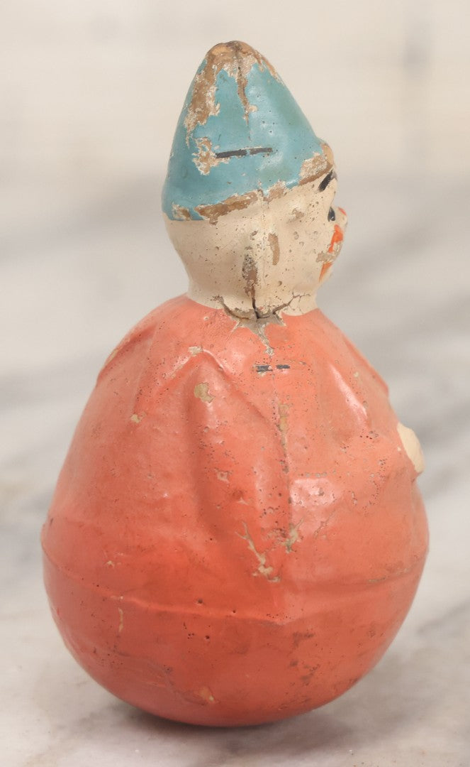 Lot 015 - Antique Papier Mache Clown Roly Poly Toy With Pink Body, Pink Makeup And Blue Hat, Note Wear And Tear Throughout, Height 3-3/4"
