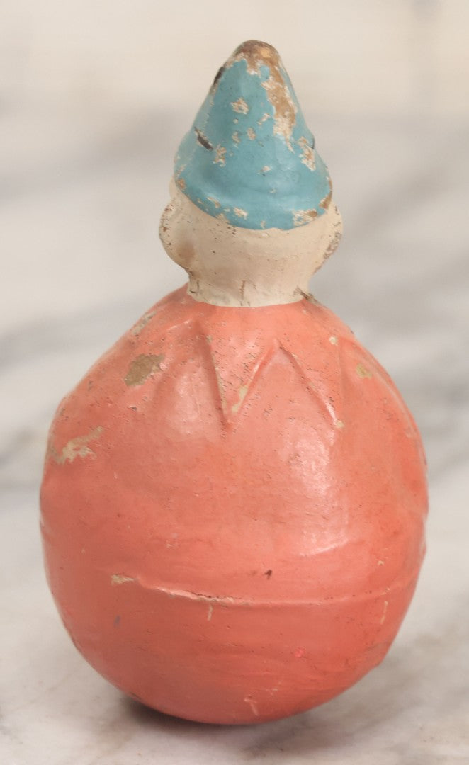 Lot 015 - Antique Papier Mache Clown Roly Poly Toy With Pink Body, Pink Makeup And Blue Hat, Note Wear And Tear Throughout, Height 3-3/4"
