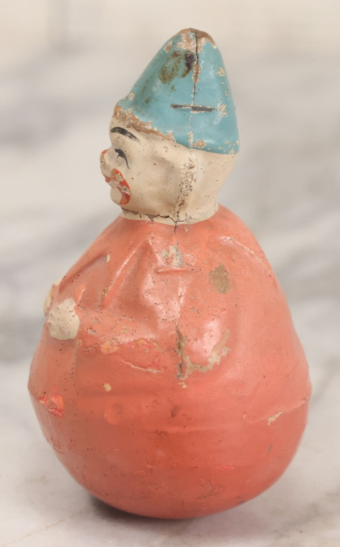 Lot 015 - Antique Papier Mache Clown Roly Poly Toy With Pink Body, Pink Makeup And Blue Hat, Note Wear And Tear Throughout, Height 3-3/4"