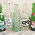 Lot 057 - Grouping Of Nine Vintage Glass Soda Bottles Including Coca-Cola, Cott, Min-R-Ize, Elk Club, Knight Club, Nugget, S&O'K, Rummy Grapefruit Drink, And Stafford Springs