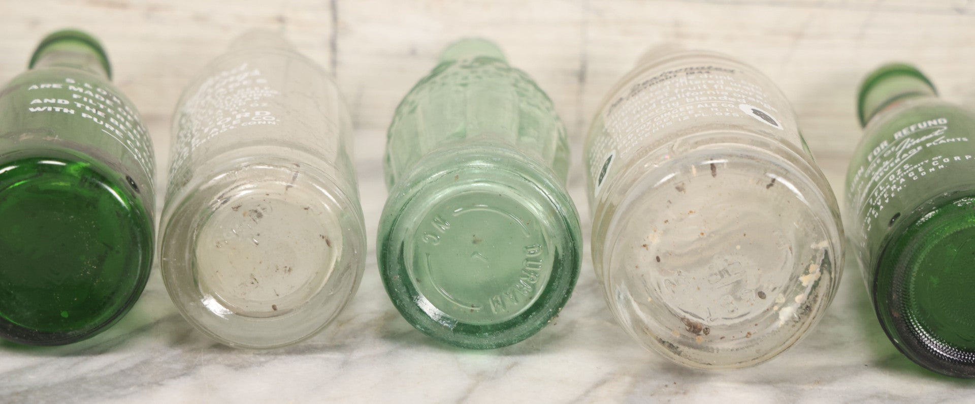 Lot 057 - Grouping Of Nine Vintage Glass Soda Bottles Including Coca-Cola, Cott, Min-R-Ize, Elk Club, Knight Club, Nugget, S&O'K, Rummy Grapefruit Drink, And Stafford Springs