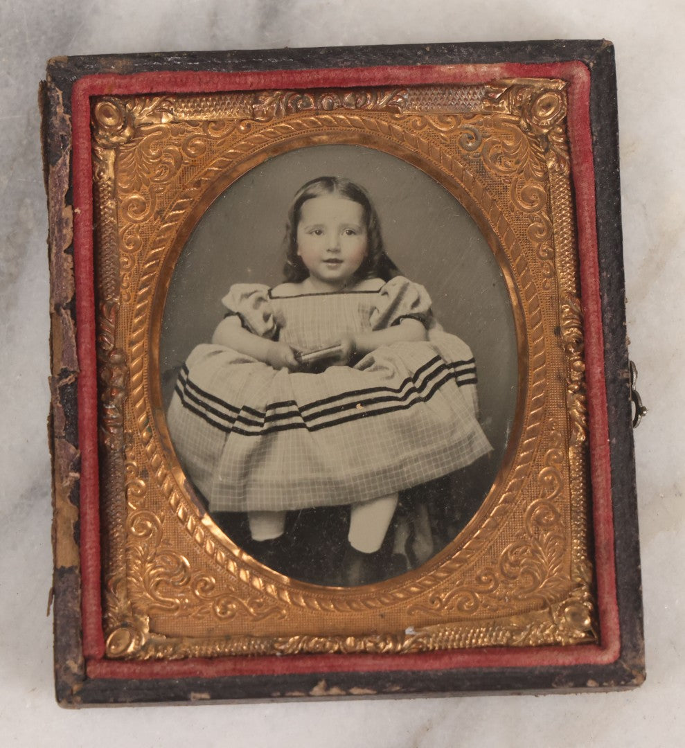 Lot 070 - Antique 1/6th Plate Ruby Ambrotype Photograph Of Smiling Little Girl With Red Tinted Cheeks, Curly Hair, Holding Books, Photograph Taken At Forbes New Gallery, Westfield, Massachusetts, In Half Leatherette Case