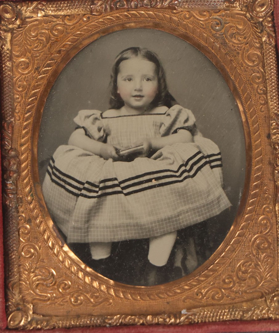 Lot 070 - Antique 1/6th Plate Ruby Ambrotype Photograph Of Smiling Little Girl With Red Tinted Cheeks, Curly Hair, Holding Books, Photograph Taken At Forbes New Gallery, Westfield, Massachusetts, In Half Leatherette Case