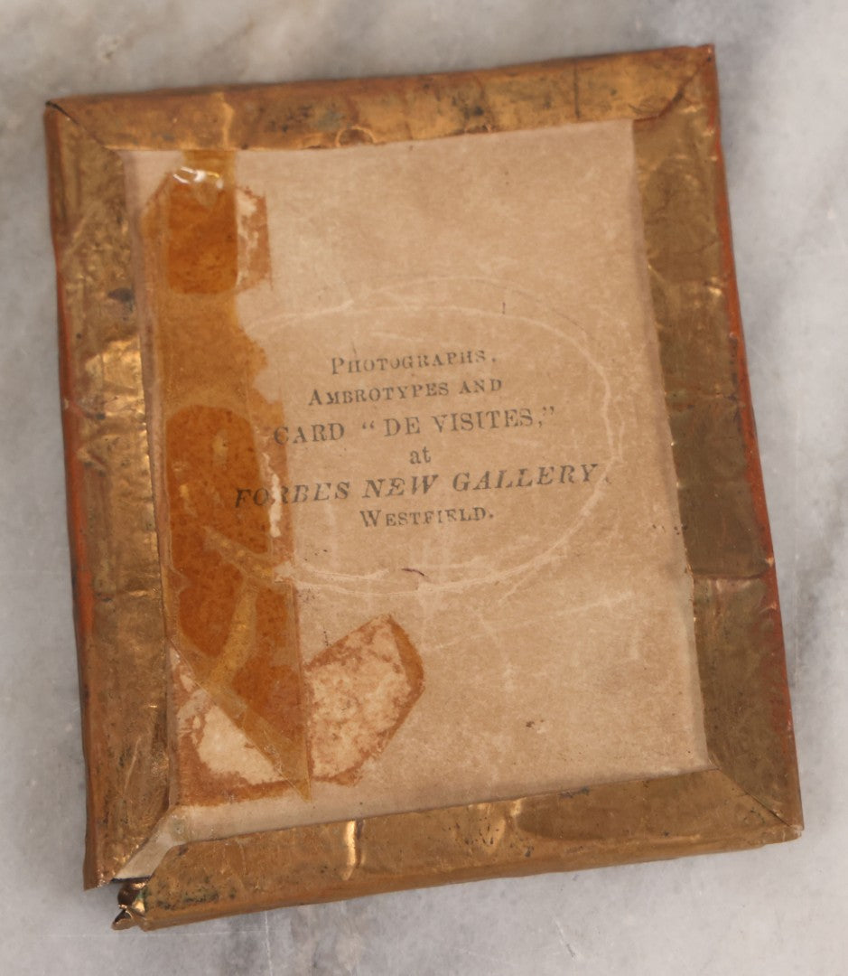 Lot 070 - Antique 1/6th Plate Ruby Ambrotype Photograph Of Smiling Little Girl With Red Tinted Cheeks, Curly Hair, Holding Books, Photograph Taken At Forbes New Gallery, Westfield, Massachusetts, In Half Leatherette Case