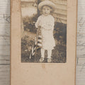 Lot 076 - Antique Boarded Photograph Of Young Child In Striped Shirt And Hat Standing With An American Flag In The Grass