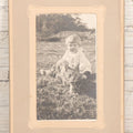 Lot 078 - Antique Snapshot Photograph In Paper Board Frame Of Little Girl Named Gladis With Blond Hair Sitting In Grass With Cat Named Toby, Identified On Verso