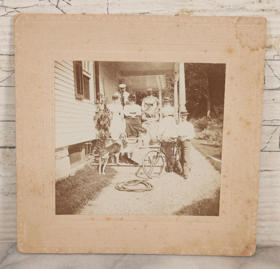 Lot 082 - Antique Boarded Photograph Of Group Of Men Women And Children Standing On Stoop Of Home With Dog And Bicycle