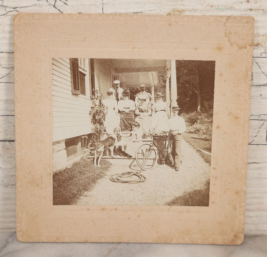 Lot 082 - Antique Boarded Photograph Of Group Of Men Women And Children Standing On Stoop Of Home With Dog And Bicycle