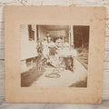 Lot 082 - Antique Boarded Photograph Of Group Of Men Women And Children Standing On Stoop Of Home With Dog And Bicycle