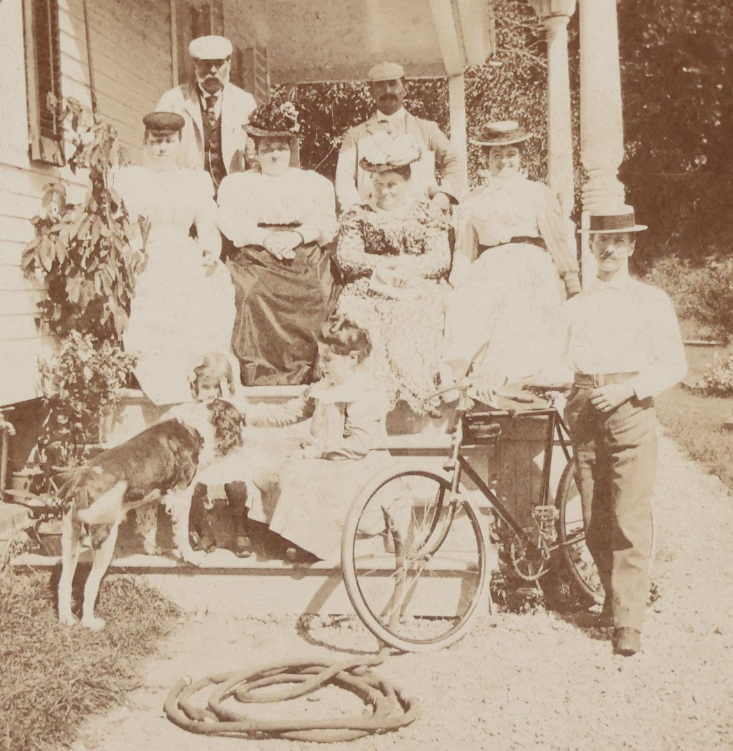 Lot 082 - Antique Boarded Photograph Of Group Of Men Women And Children Standing On Stoop Of Home With Dog And Bicycle