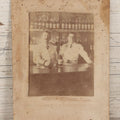 Lot 083 - Antique Boarded Occupational Photograph Of Two Bartenders Standing Behind Bar Posing With Bottles Of Elks Club Whiskey, Other Advertisements Visible Including For Boston Cadet Cigars, Note Damaged Upper Right Corner