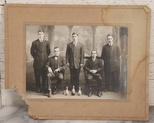 Lot 084 - Antique Boarded Photograph Of Bowling Team Of Five Men Posing With Three Bowling Pins And Bowling Ball, Note Loss To Lower Left Corner, Hole To Left Of Center Mans Head