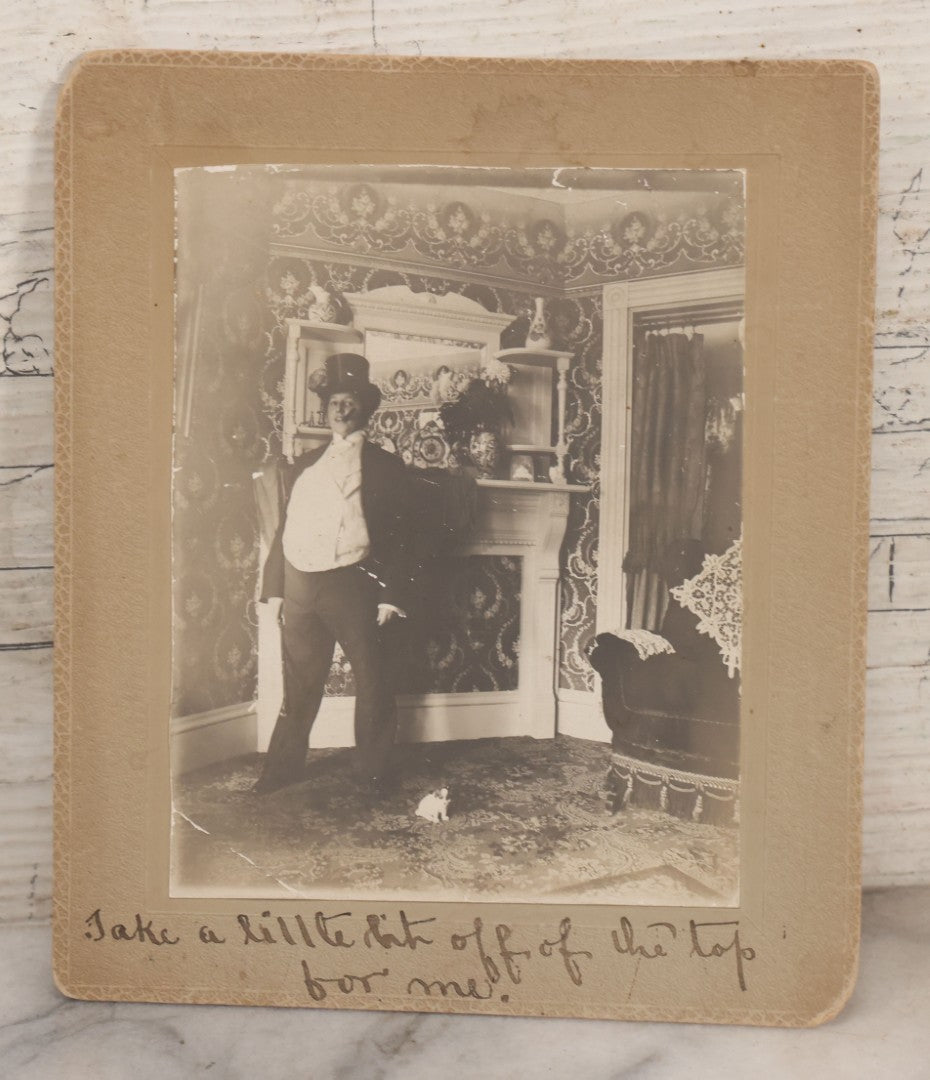 Lot 086 - Antique Boarded Interior Photograph Of Woman Dressed In Suit And Top Hat Smoking Cigar, With Handwritten Caption "Take A Little Bit Off The Top For Me" With Little Dog Figurine