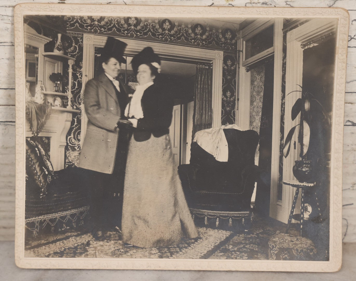 Lot 087 - Antique Boarded Interior Photograph Of Two Women, One Dressed In Suit And Top Hat, Dancing In Parlor