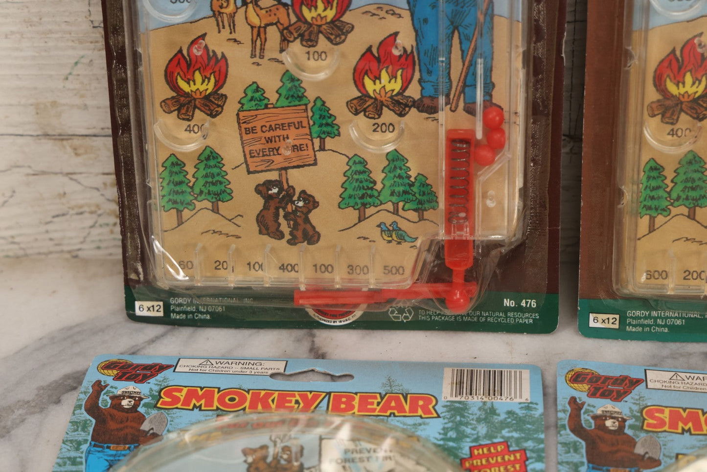 Lot 089 - Grouping Of Eight New Old Stock N.O.S. Smokey Bear "Put Out The Fires..." Pinball Game, Manufactured By Gordy International, Inc., Plainfield, New Jersey, No. 476, Made In China