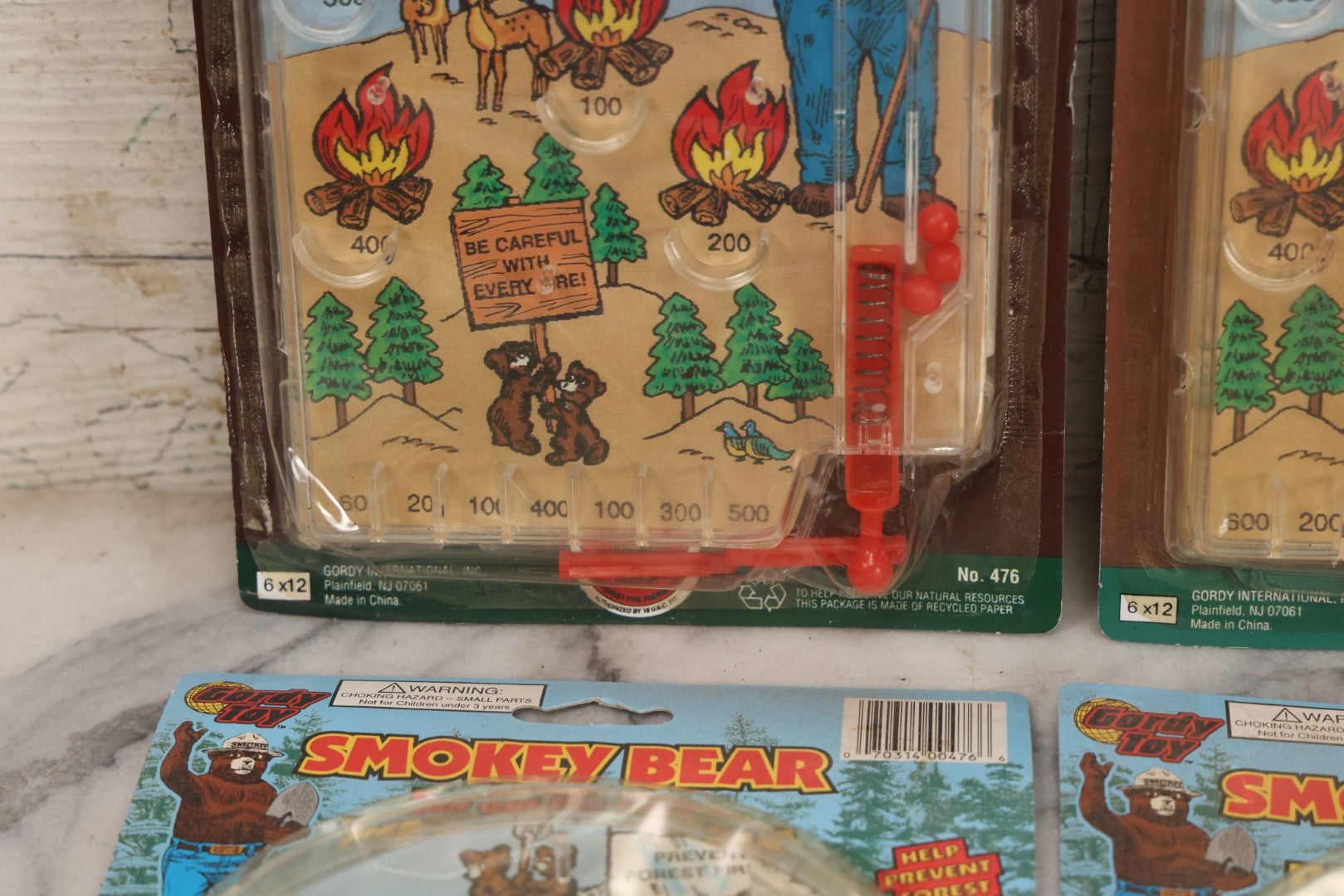 Lot 089 - Grouping Of Eight New Old Stock N.O.S. Smokey Bear "Put Out The Fires..." Pinball Game, Manufactured By Gordy International, Inc., Plainfield, New Jersey, No. 476, Made In China