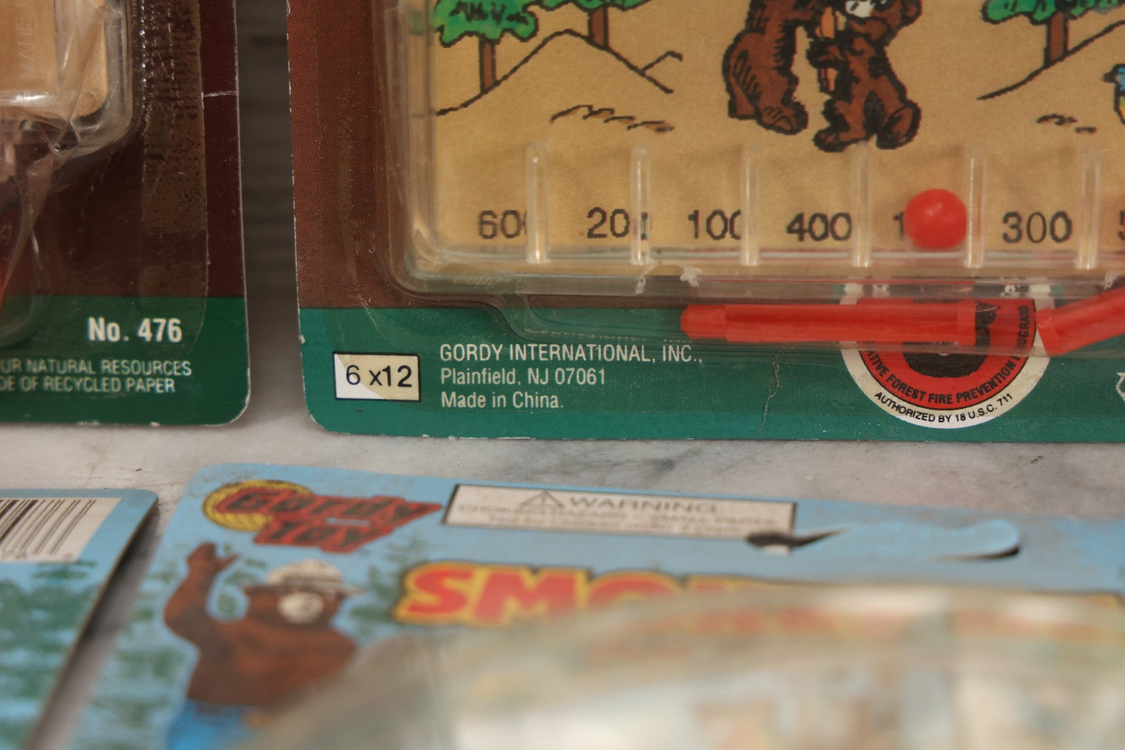 Lot 089 - Grouping Of Eight New Old Stock N.O.S. Smokey Bear "Put Out The Fires..." Pinball Game, Manufactured By Gordy International, Inc., Plainfield, New Jersey, No. 476, Made In China