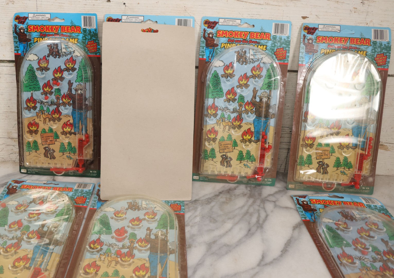 Lot 089 - Grouping Of Eight New Old Stock N.O.S. Smokey Bear "Put Out The Fires..." Pinball Game, Manufactured By Gordy International, Inc., Plainfield, New Jersey, No. 476, Made In China