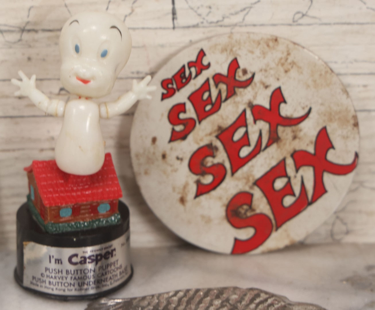 Lot 090 - Miscellaneous Novelties Grouping Including Casper The Friendly Ghost Push Button Puppet, Rusty Sex Pinback Button, Four "Inflated States Of America" Richard Nixon Dollars, Little Tacos 3D View Comic Book, Toy Sports Car, And Tin Fish