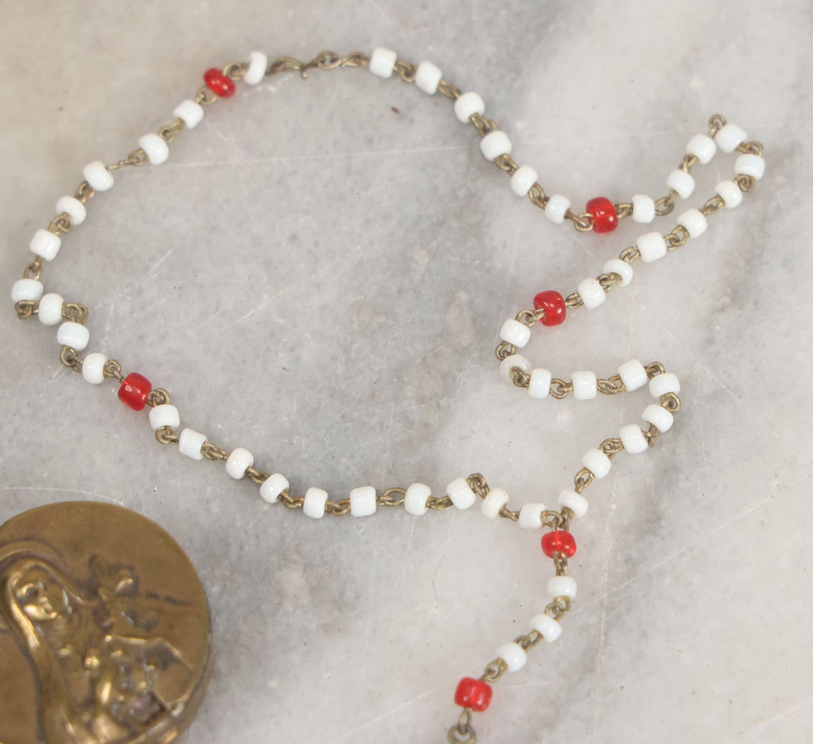 Lot 016 - Vintage Miniature White And Red Glass Rosary Beads With Crucifix In Button Sized Metal Carrying Case With Embossed Saint Therese