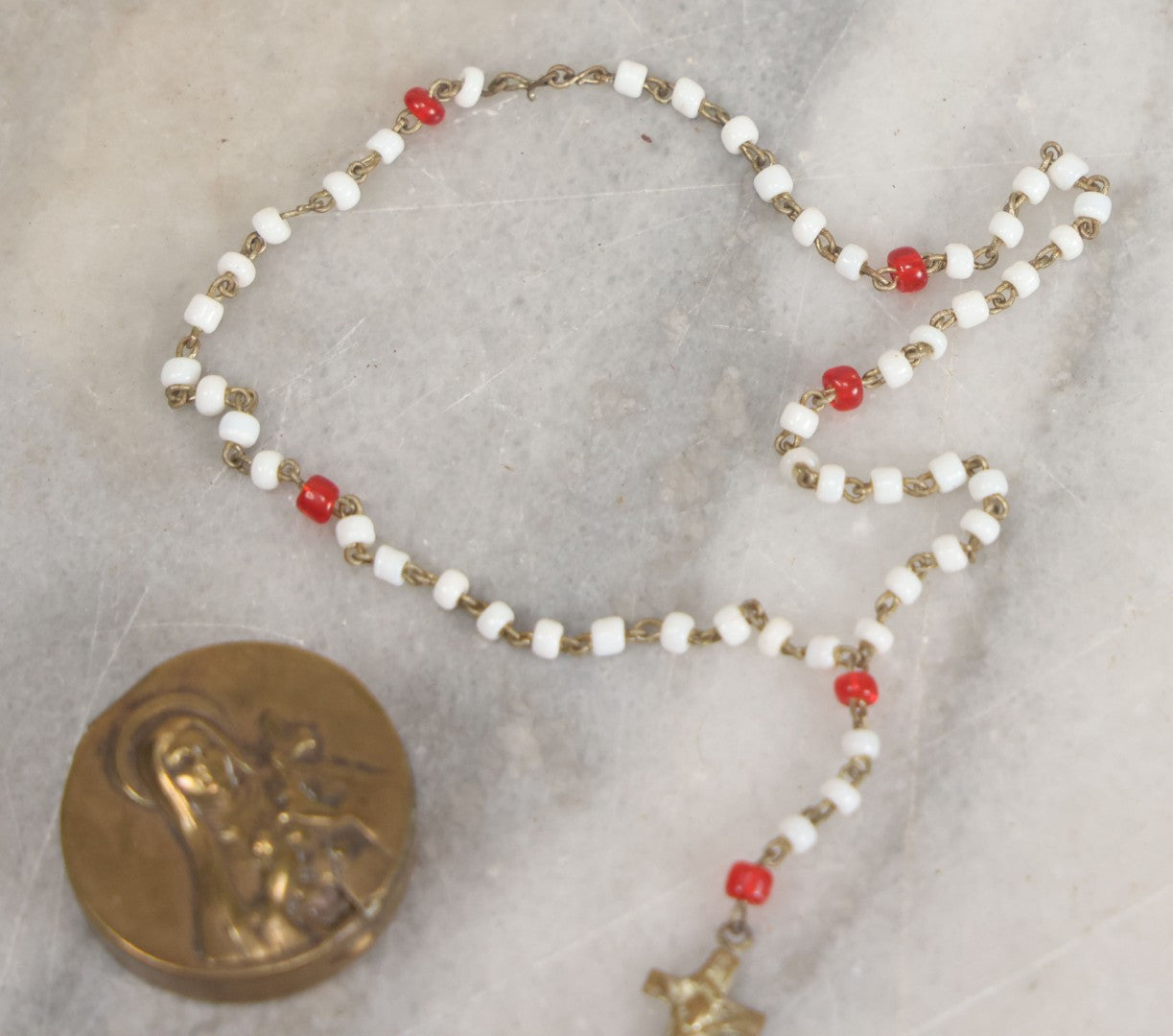 Lot 016 - Vintage Miniature White And Red Glass Rosary Beads With Crucifix In Button Sized Metal Carrying Case With Embossed Saint Therese