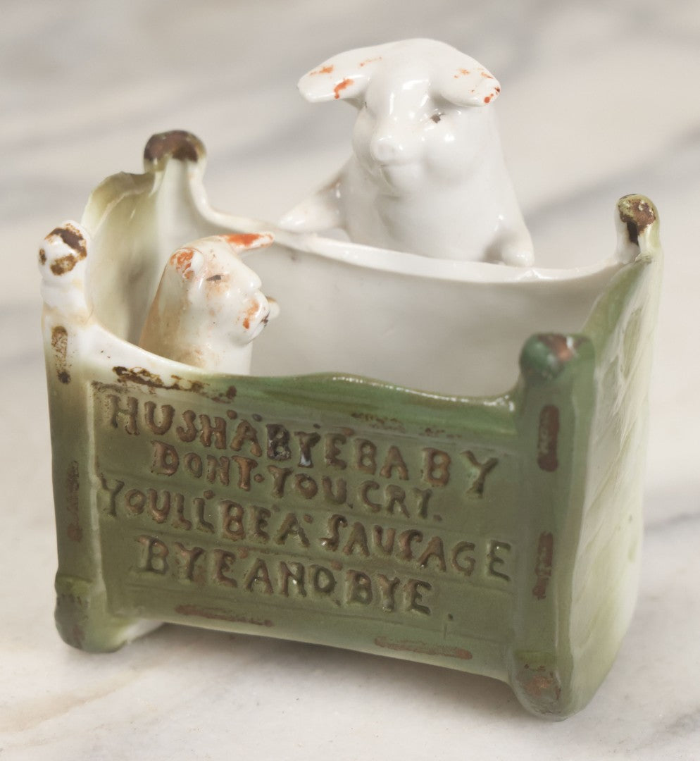 Lot 027 - Antique Porcelain Novelty Vessel With Mama Pig And Pig In Cradle, "Hush Hushabye Baby, Don't You Cry, You'll Be A Sausage Bye And Bye," Stamped Germany, With Remnants Of Original Paint, Note Cracks And Repairs
