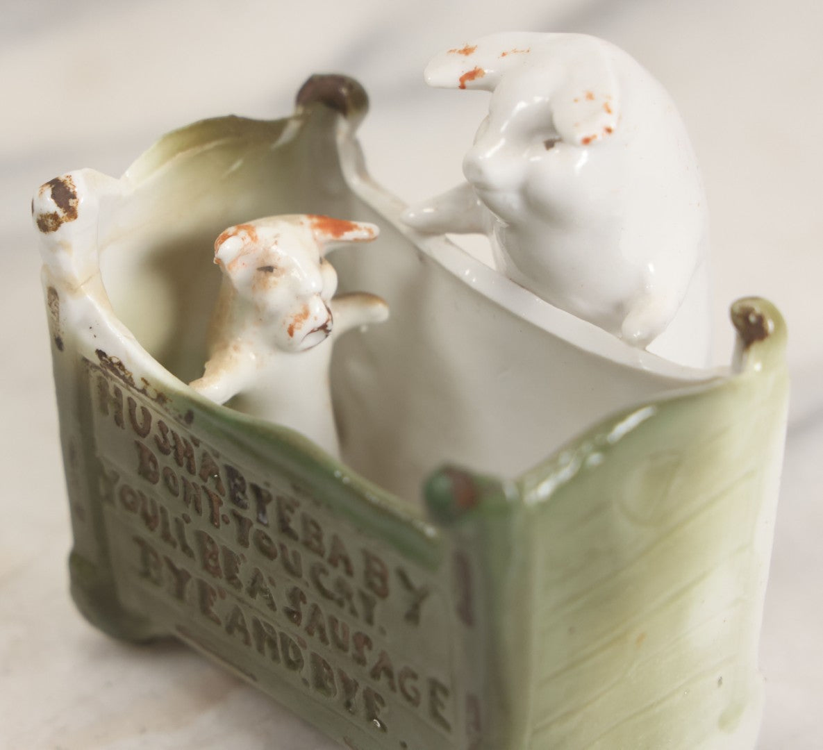 Lot 027 - Antique Porcelain Novelty Vessel With Mama Pig And Pig In Cradle, "Hush Hushabye Baby, Don't You Cry, You'll Be A Sausage Bye And Bye," Stamped Germany, With Remnants Of Original Paint, Note Cracks And Repairs