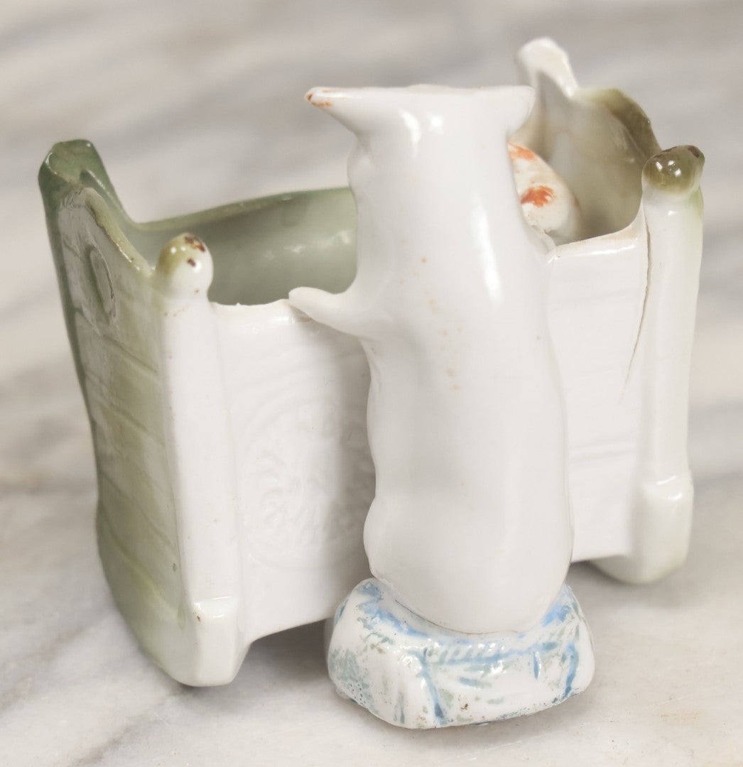 Lot 027 - Antique Porcelain Novelty Vessel With Mama Pig And Pig In Cradle, "Hush Hushabye Baby, Don't You Cry, You'll Be A Sausage Bye And Bye," Stamped Germany, With Remnants Of Original Paint, Note Cracks And Repairs