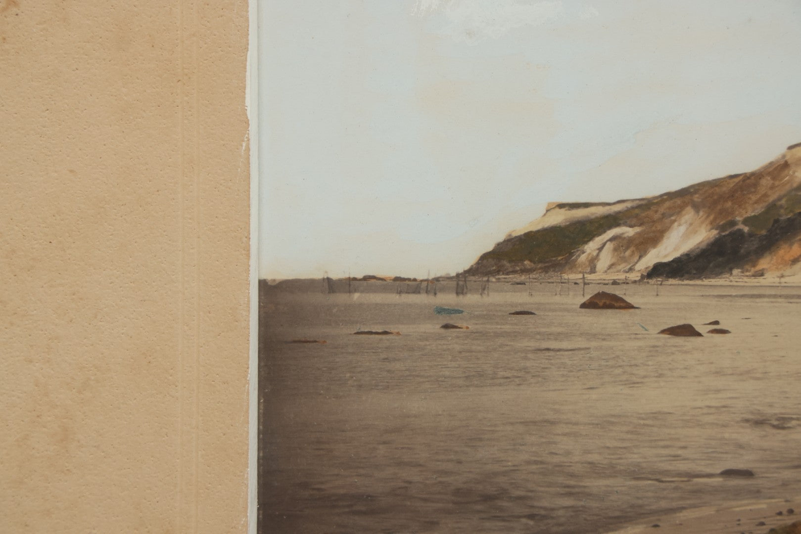 Lot 033 - Antique Painted Over Photograph Of Oceanside Cliffs And Beach With Child Seated On Rocks Likely Gay Head Cliffs, Martha's Vineyard, Massachusetts, In Original Frame, 17-1/2" x 15-1/2"