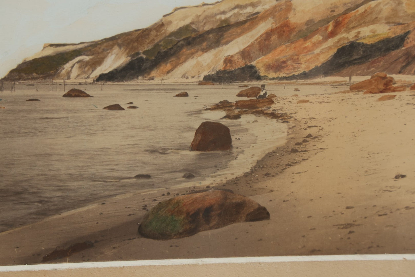 Lot 033 - Antique Painted Over Photograph Of Oceanside Cliffs And Beach With Child Seated On Rocks Likely Gay Head Cliffs, Martha's Vineyard, Massachusetts, In Original Frame, 17-1/2" x 15-1/2"