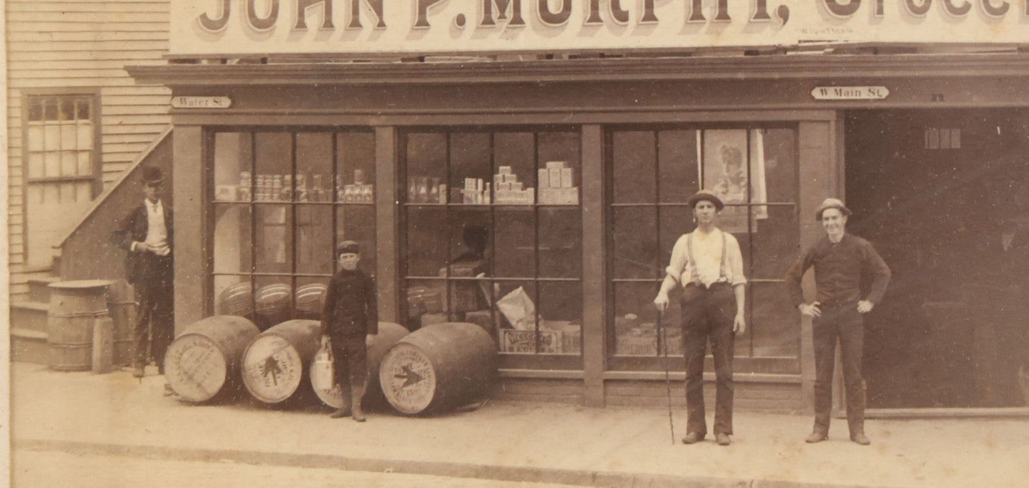 Lot 035 - Antique Occupational Photograph Depicting The Proprietors And Workers Of John P. Murphy Groceries And Provisions General Store, Located On West Main Street, Unknown City, Dog Visible In Photograph, In Period Frame, As Found, 11-1/2" x 8-1/2"
