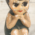 Lot 044 - Vintage Chalkware Kewpie-Style Crouching Flapper Doll With Black Hair And Green Dress, Back Marked "Splash Me", Note Paint Chipping And Wear, 4-3/4" Height