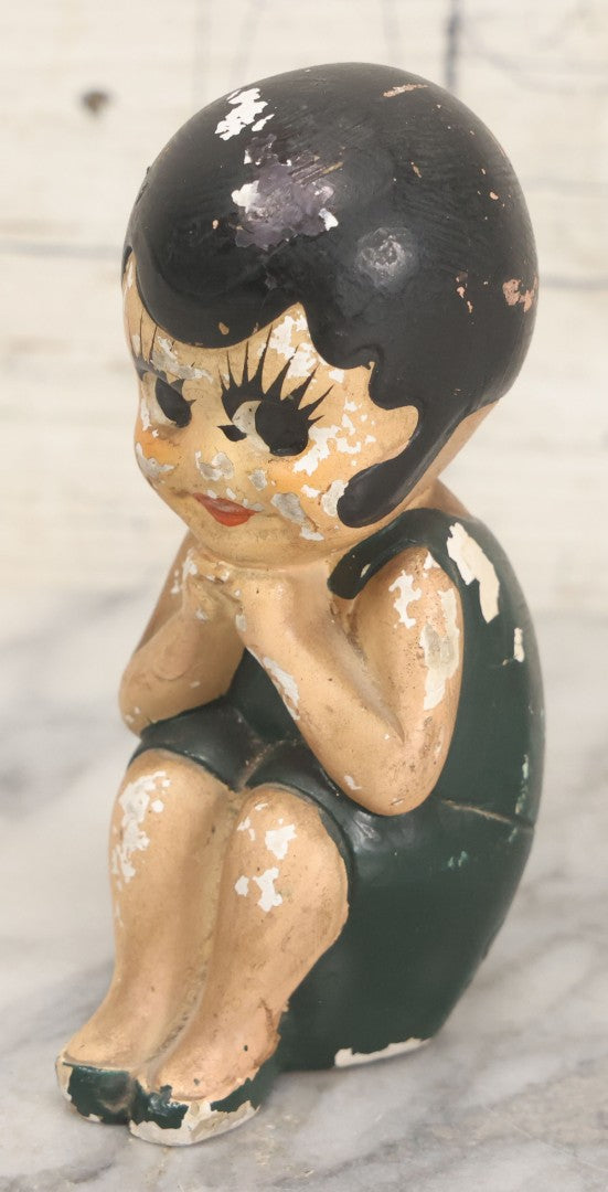Lot 044 - Vintage Chalkware Kewpie-Style Crouching Flapper Doll With Black Hair And Green Dress, Back Marked "Splash Me", Note Paint Chipping And Wear, 4-3/4" Height